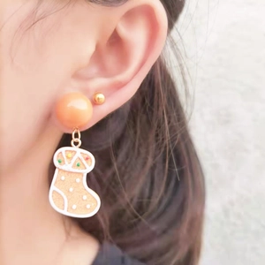 Asymmetric handmade gingerbread man and Christmas sock earrings worn by model