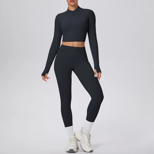 Détail d'un ensemble de yoga noir taille haute avec passe-pouces et veste ajustée