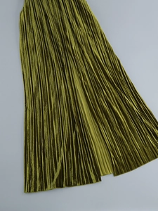Détail du tissu de jupe plissée verte avec texture velours métallique et éclat fin