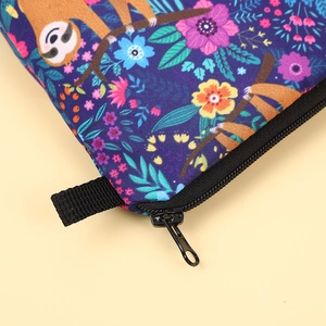 Detailed macro view of the black zipper and side handle on a fabric sloth travel pouch