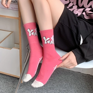 Pink mid-calf cotton socks with white YEAH lettering and cute floral patterns