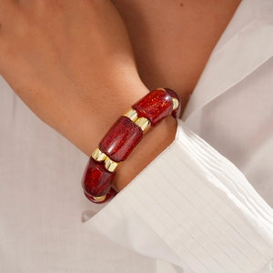 Detail of red glitter acrylic beads and gold spacers on a stylish stretch bracelet