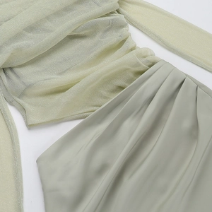 Detail of off-shoulder mesh dress in sage green featuring pleated satin and shimmering fabric
