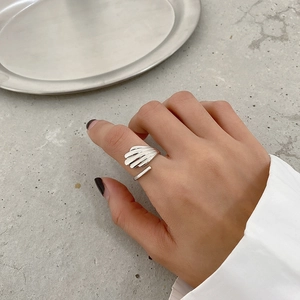 Macro detail of silver shell texture open ring featuring polished adjustable metal band