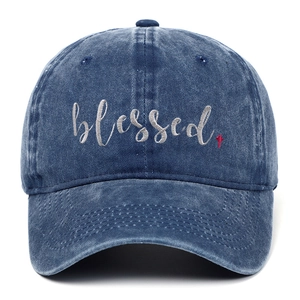Detailaufnahme der grauen Blessed-Stickerei und des roten Kreuzes auf der Denim-Kappe
