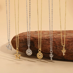 Star and key pendants with zircon crystals in gold and silver plating on wood