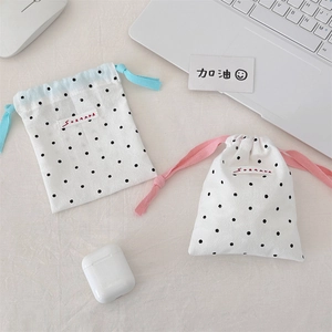 Detail of polka dot drawstring storage bags with blue and pink cords for cosmetics