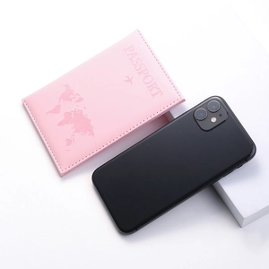 Pink PU leather passport holder with world map and airplane design shown next to a smartphone