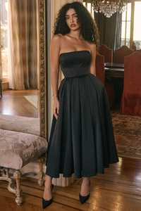 Detail of elegant black strapless midi dress featuring boned corset and pleated A-line skirt