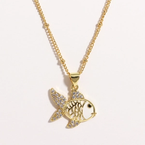 Close-up of gold-plated goldfish pendant with white enamel and sparkling rhinestones