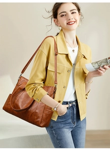 Brown PU leather tote bag worn by a model in a casual denim outfit style