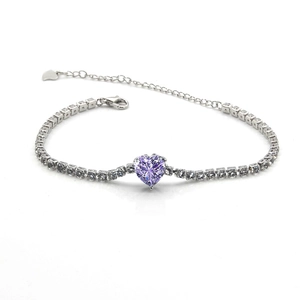 Détail d'une pierre violette en forme de cœur sur un bracelet de type tennis argenté