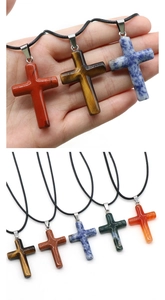 Detailed macro view of 40mm natural stone cross pendants with adjustable black neck cords
