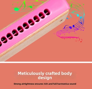 Detail of pink 16-hole wooden harmonica showing airtight blow holes and smooth finish