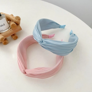Detail of light blue and pink pleated fabric headbands with elegant knotted design