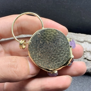 Makroaufnahme von 14K vergoldetem Katzenpfoten-Anhänger mit natürlichen Amethyst-Kristallen
