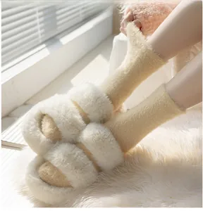 Close-up of fluffy beige faux fur slippers paired with thick yellow coral fleece socks