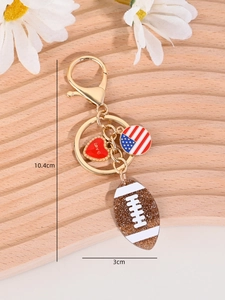 Detail of American football keychain with glitter pendant and US flag charm on wood