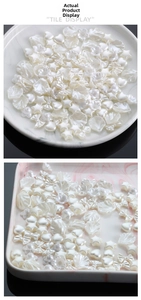 Close-up of pearlized white acrylic charms in star, heart, and bow shapes for DIY jewelry
