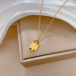 Close-up of gold titanium necklace with Auspicious pendant on white silk fabric