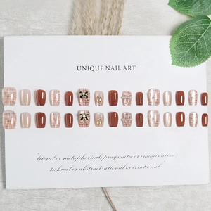 Unghie finte corte con motivi scozzesi marroni, glitter e fiocchi di perle