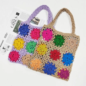 Detailed close-up of handmade crochet tote bag featuring 3D colorful floral patterns