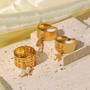 Anelli in acciaio inossidabile 18K con ciondoli stella e perla su sfondo pietra