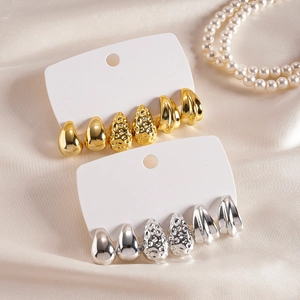Élégant ensemble de six boucles d'oreilles goutte or et argent sur fond de soie douce