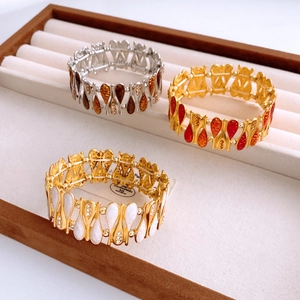 Detail of teardrop enamel cuff bracelets in brown, orange and white on a jewelry tray