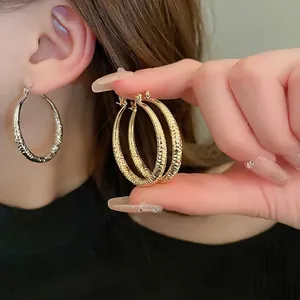 Minimalist textured hoop earrings with diamond pattern in gold and silver finish