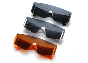 Three futuristic rimless oversized sunglasses in black, white, and orange on white background