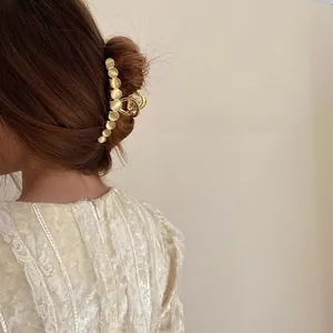 Detail of elegant gold alloy hair claw clip with opal stones worn on a model's hair