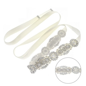 Close-up of bridal belt with white ribbon and sparkling rhinestone detailing for weddings