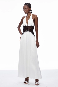 Détail de la robe longue dos nu blanche avec taille en dentelle noire et fini satiné