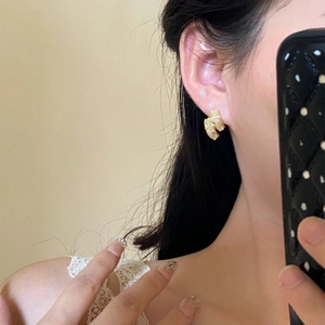 Vue détaillée des boucles d'oreilles texturées plaquées or 14k portées à l'oreille