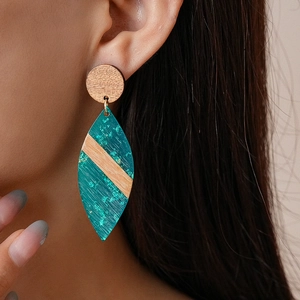 Close-up of bohemian marquise acrylic drop earrings with wood textures and green foil
