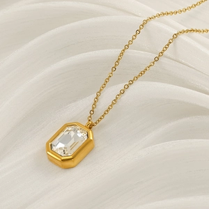 Elegant gold stainless steel necklace featuring a square zircon pendant on silk background