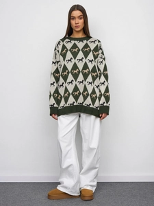 Detailed view of dark green knit sweater with argyle horse pattern and ribbed cuffs
