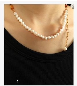 Detail shot of irregular freshwater pearls and gold metal chain on necklace for women