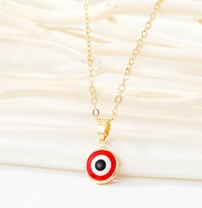 Detailed view of evil eye pendant on gold chain hung on natural white branches