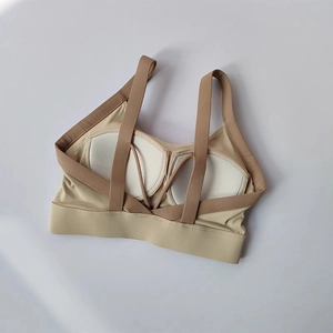 Detail of cross-back yoga bra showing removable padding and beige moisture-wicking fabric