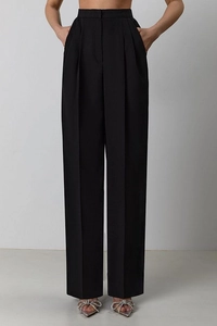 Close-up of black high-waisted wide-leg trousers with elegant front pleat detail