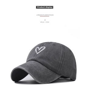 Close-up of heart embroidery on washed dark grey cotton baseball cap with stitch detail
