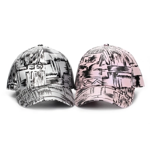 Detail showing metallic PU finish and abstract graffiti print on baseball caps