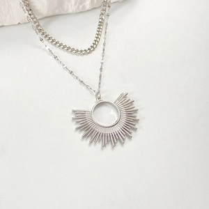 Détail du collier argenté double épaisseur avec chaîne cubaine et pendentif soleil