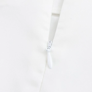 Detailed close-up of a high-quality white invisible zipper on an elegant skirt set