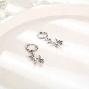 Polished silver balloon dog charm hoop earrings for women on wavy white display