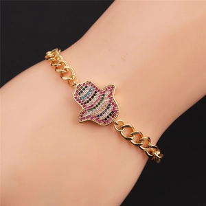 Détail du bracelet Hamsa en or avec zircons colorés sur une chaîne à maillons cubains