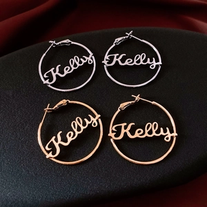 Close-up of 18K gold and silver plated hoop earrings featuring Kelly name design
