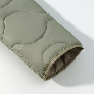 Macro detail of onion-quilted olive jacket sleeve with premium stitching and smooth texture